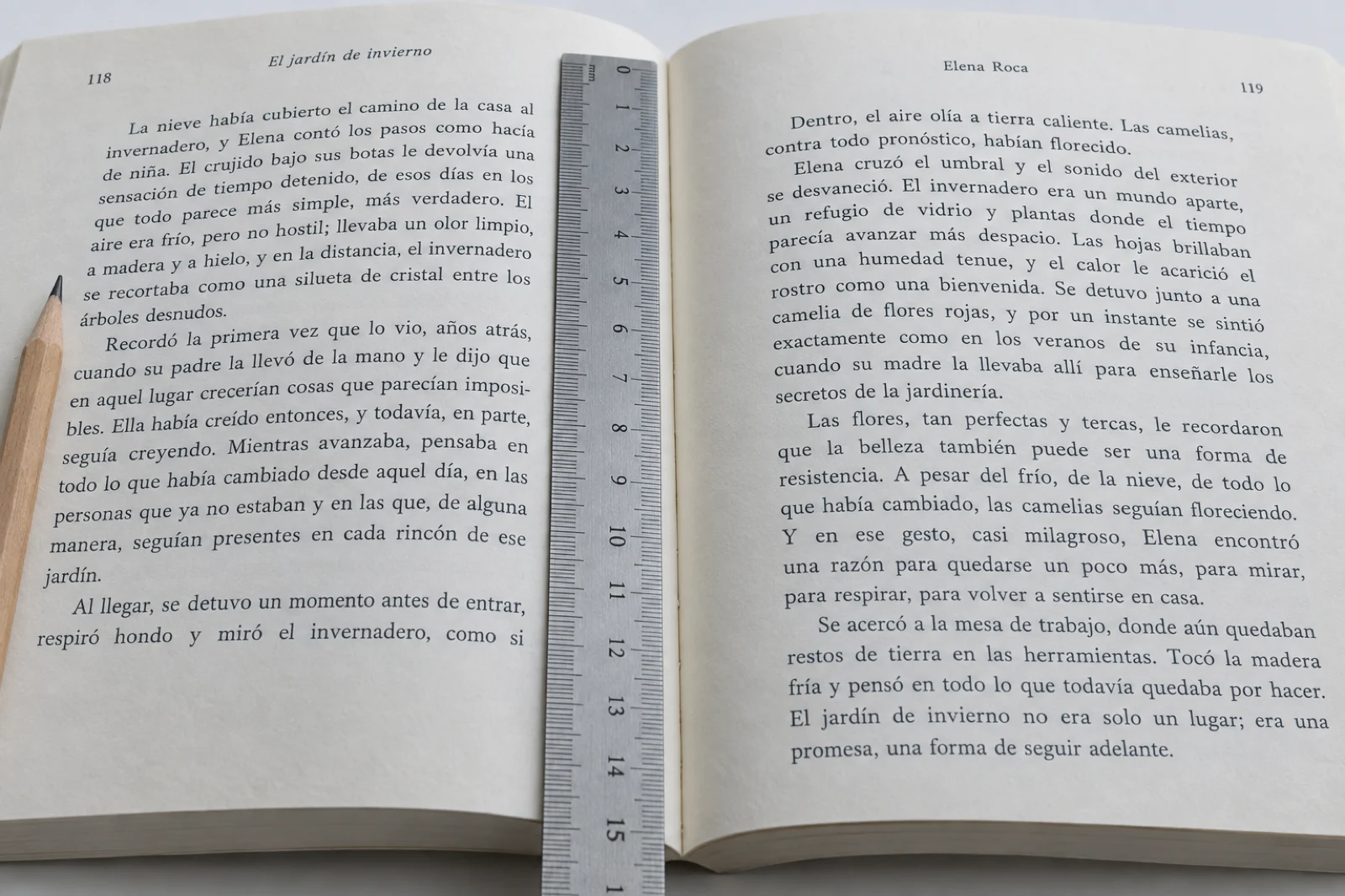 Novela 'El jardín de invierno', de Elena Roca, abierta por las páginas 118 y 119, con el texto legible y una regla de acero midiendo el margen interior
